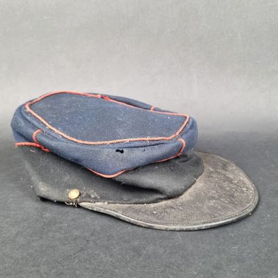 un chapeau bleu orné d'une couture rouge