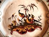 a decorative plate with birds and flowers on it