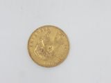 a gold coin on a white surface with a white background