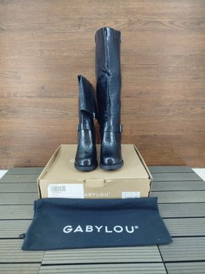 les bottes noires sont posées sur une boîte, elle-même posée sur une table