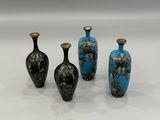 three vases are sitting on a white surface, one has blue and the other has gold
