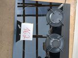 une plaque de cuisson noire à deux feux, sur laquelle est apposée une pancarte
