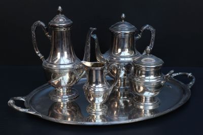 a silver tray with a silver tea set on it