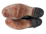 a pair of brown shoes that are on a white surface