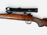 the rifle is laying on a white surface with a light on it