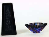 un petit bol en verre bleu à côté d'un petit vase noir