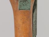 a close up of a wooden object with a green patt on it