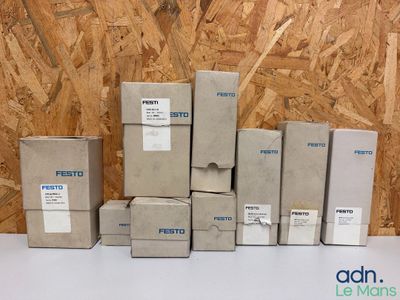 Plusieurs cartons sont empilés les uns sur les autres devant un mur en bois.
