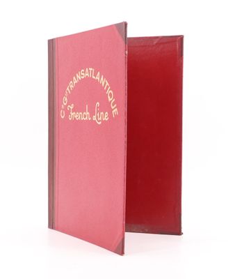 un livre rouge ouvert sur une surface blanche
