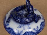 a small blue and white plate with a lizard on it