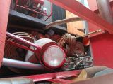 a red fire truck with a bunch of hoses in the back