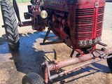 un tracteur rouge qui est garé dans la terre