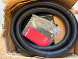 an open box with a black hose and a red box with a black hose