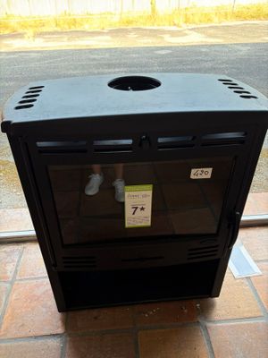 a black stove sitting on a brick floor in front of a window