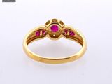 a close up of a gold ring with a ruby stone