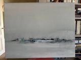 a painting that is sitting on a table in front of a bookshelf