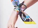 a woman ' s hand with a colorful tie on her wrist