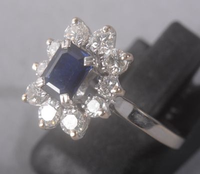 un gros plan d'une bague sertie de diamants et de saphirs, posée sur un présentoir