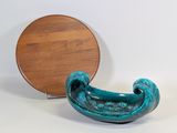 un petit bol bleu posé à côté d'une assiette en bois