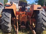 a tractor that is sitting in the grass near a building