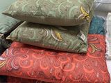 many pillows and pillows on a table in a room