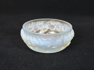 un petit bol en verre orné d'un motif en dentelle