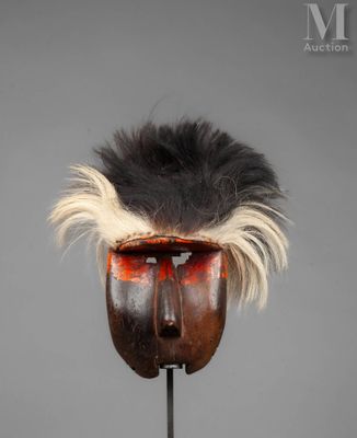 a close up of a wooden mask on a metal stand