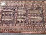 un vieux tapis posé par terre, sur lequel est accrochée une étiquette