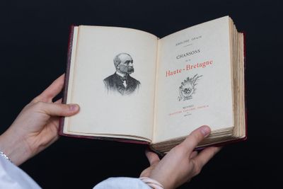 a person holding an open book with a drawing of a man