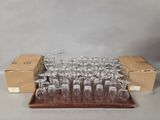 Plusieurs verres à vin vides sont posés sur un plateau devant une boîte