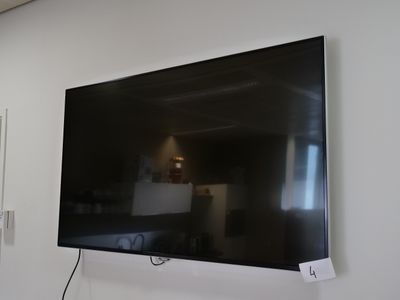 un téléviseur à écran plat fixé au mur d'une pièce