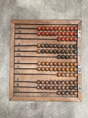 an old wooden abacuse with numbers on it on a concrete surface