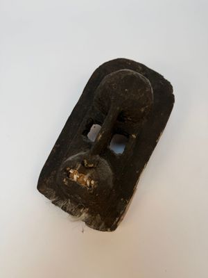 un objet noir posé sur une surface blanche et percé d'un trou