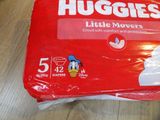 a bag of huggies sitting on a table next to a bag of diapers
