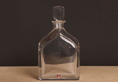 une bouteille en verre transparent posée sur une table en bois