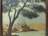 framed picture of a painting of a landscape with a castle in the distance