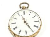 une montre de poche en or avec des chiffres romains sur le cadran