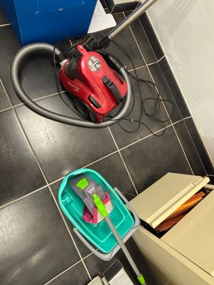 deux aspirateurs et une boîte posés par terre dans la salle de bains