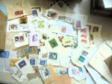 une pile de timbres posée sur une table, à côté d'une paire de ciseaux