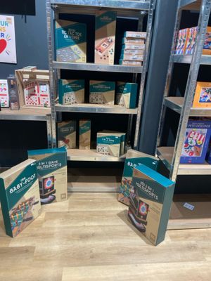 Deux livres sont posés par terre devant une bibliothèque.