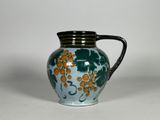 un vase bleu et vert orné de fleurs orange