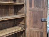 a large wooden cabinet with shelves in a room