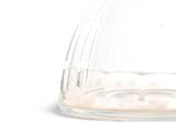 a clear glass vase with a black lid on a white surface