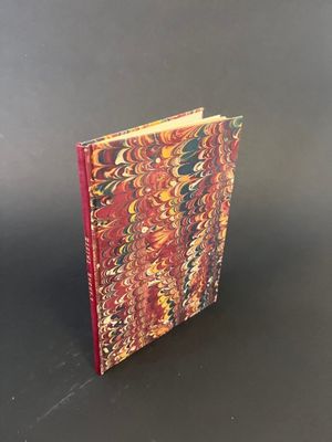 a red and yellow book sitting on top of a black table