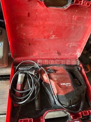 une boîte à outils rouge contenant des outils, posée sur une table