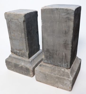 two stone pedestals sitting next to each other on a white surface
