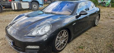 une photo d'une voiture de sport noire garée sur un parking