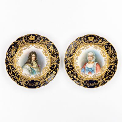 deux assiettes noires et dorées représentant le portrait d'une femme et d'un homme