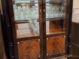 une armoire en bois avec des portes vitrées, dans une pièce