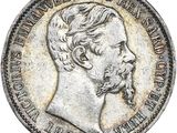 une pièce d'argent représentant le visage d'un homme barbu